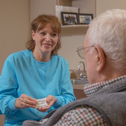 Dental team member talking to dental patient in treatment room