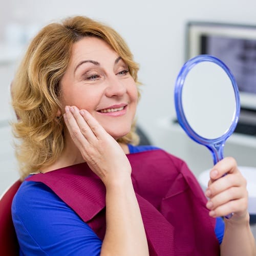 Woman looking at smile after smile makeover treatment