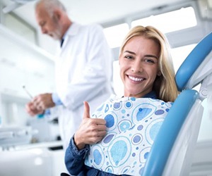 A patient in North Naples, FL pointing towards her smile