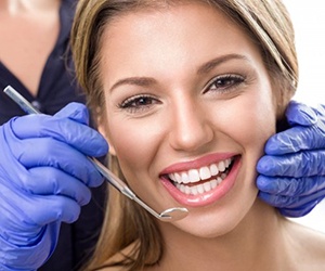 A patient paying for cosmetic dental treatment in North Naples, FL