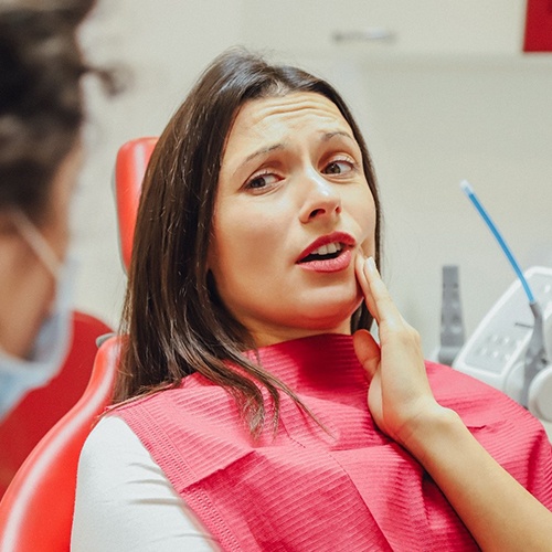 Woman experiencing dental emergency in Naples