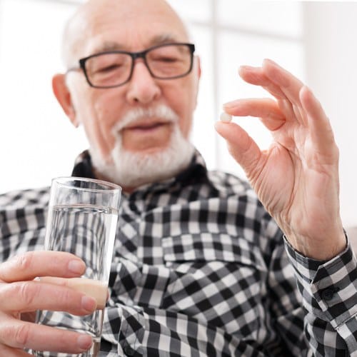 Man holding an antibiotic pill