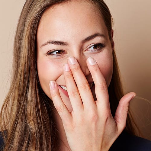 Woman with bad breath covering her mouth