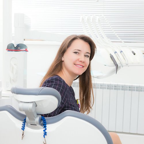 Woman smiling while looking back sitting in dental chair