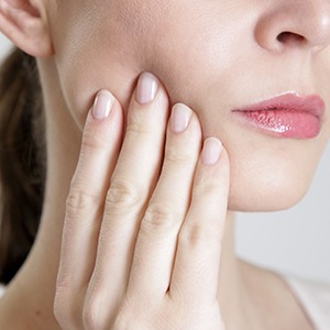 Closeup of woman with her hand on her cheek