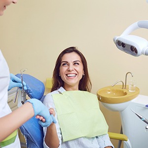 Woman shaking hands with her dentist while smiling
