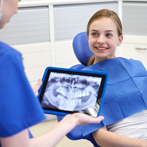 Dentist looking at digital x-rays on tablet computer