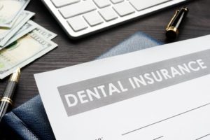 Dental insurance form next to computer and money